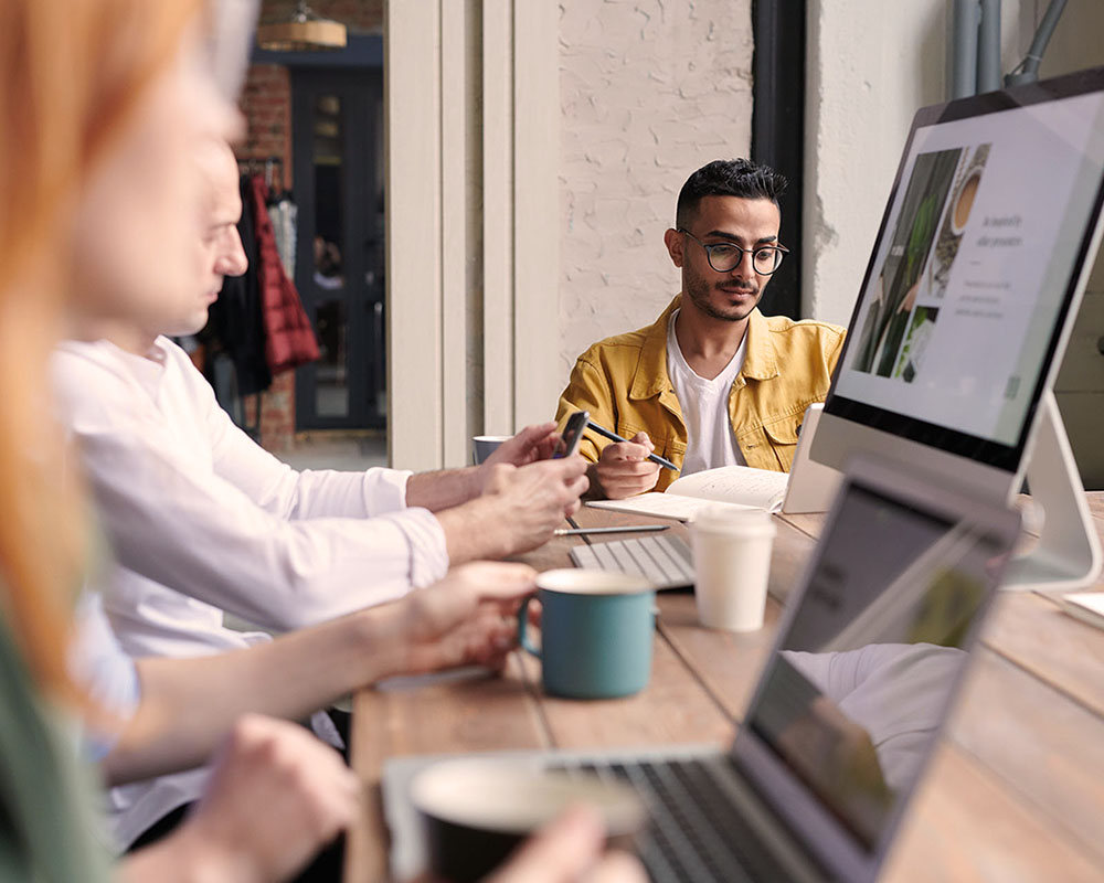 Several employees doing work on Mac computers
