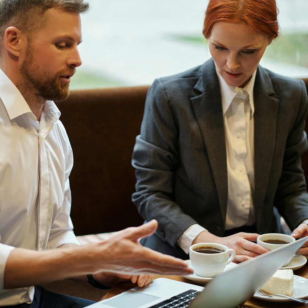 Man and woman looking at a MacBook computer