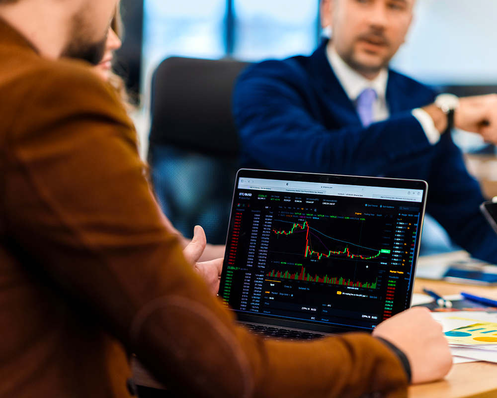 MacBook computer showing graphs of market trends