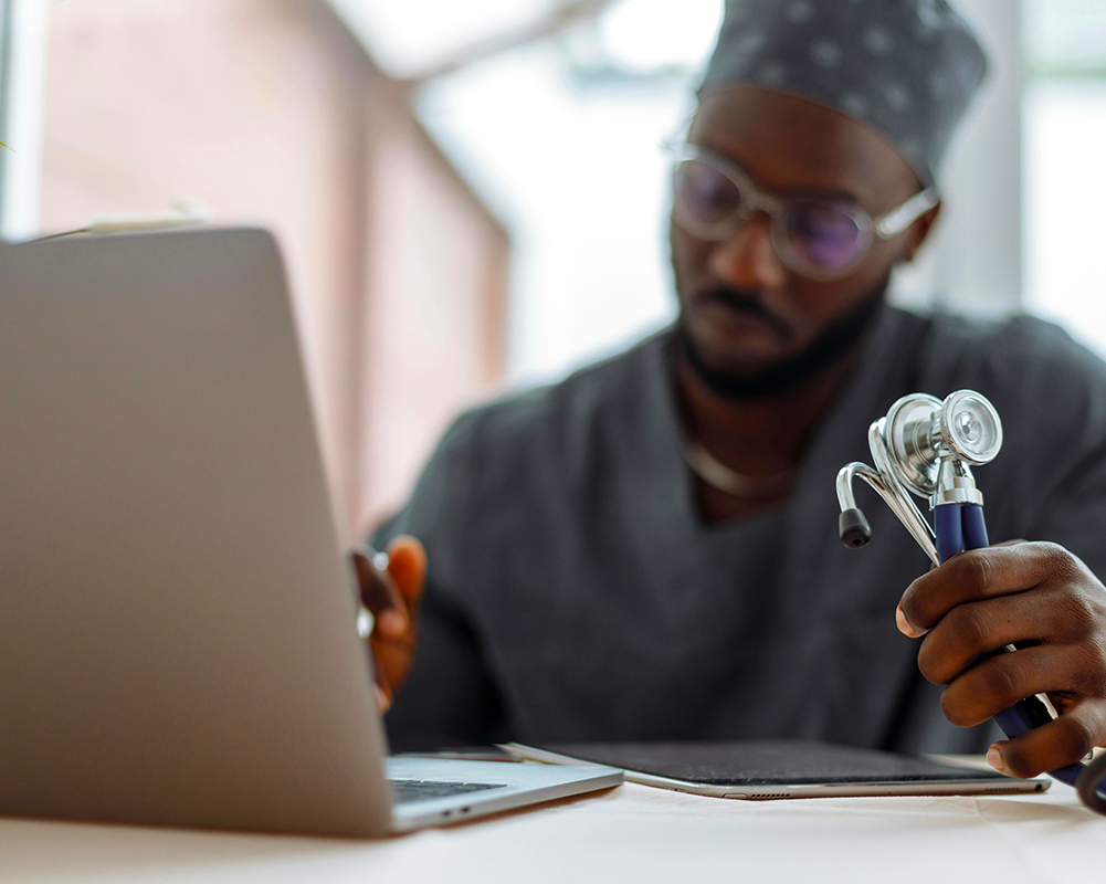 Doctor filling up a form on his iPad and MacBook